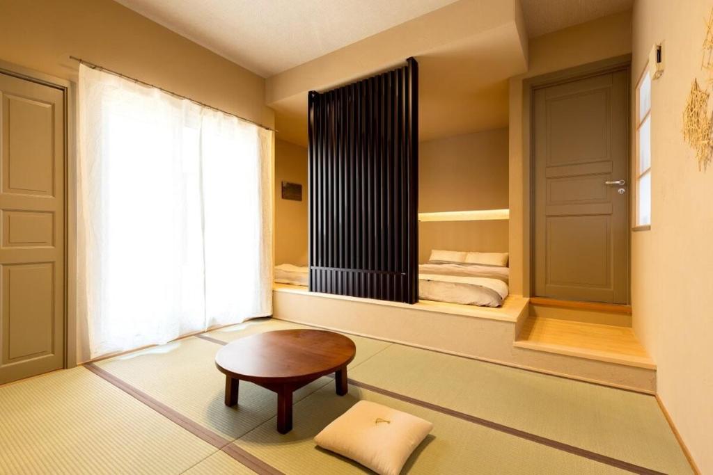 a room with a table and a window and towels at お宿 想-Oyado Sou- in Asakura