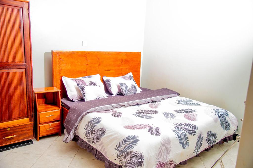 a bedroom with a bed with a wooden headboard at Kasese Explorers Homestay in Kasese