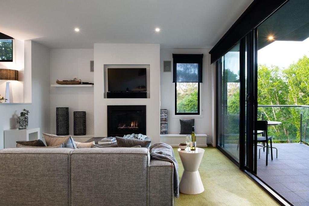 a living room with a couch and a fireplace at Saltus One bedroom- luxury and panoramic views in Hepburn Springs