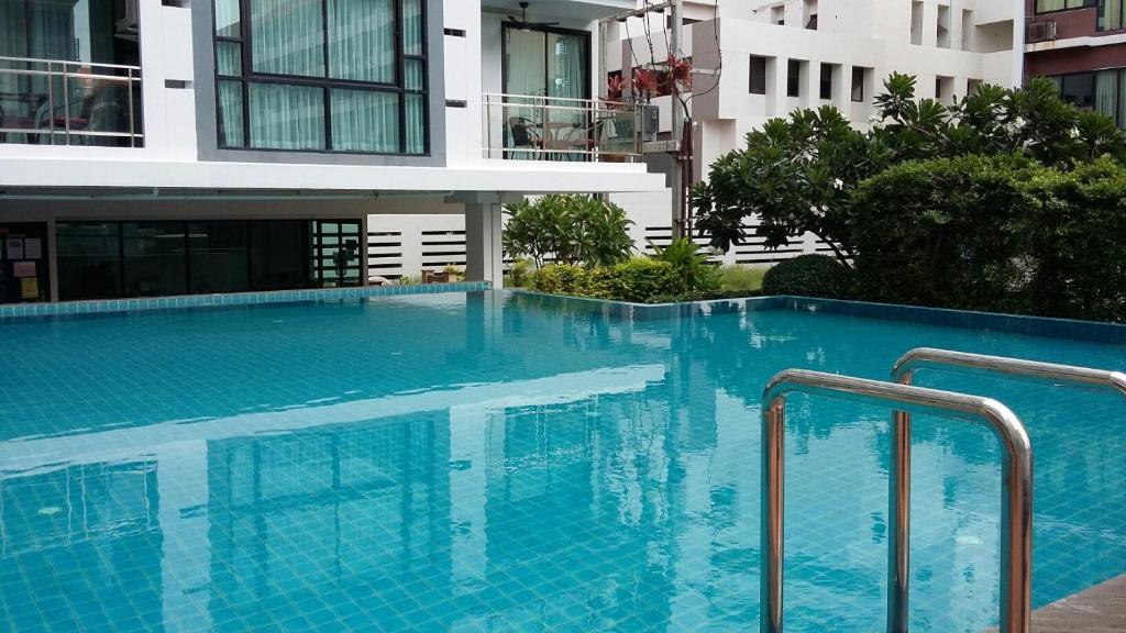 une grande piscine bleue en face d'un bâtiment dans l'établissement Neo Condo by Jean, à Jomtien Beach