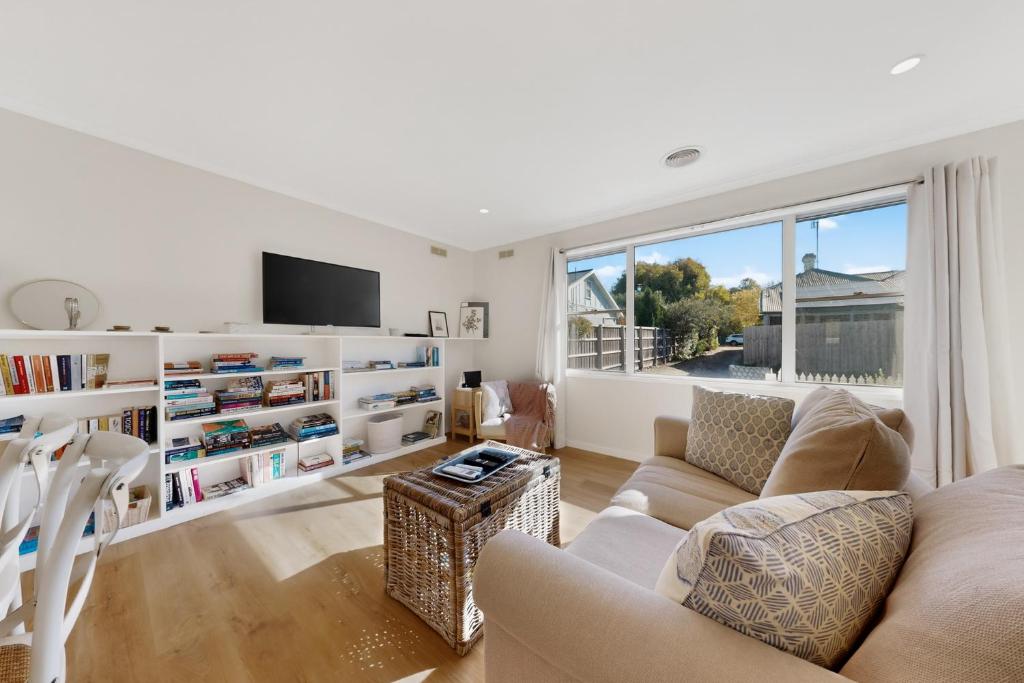 a living room with a couch and a tv at Charming Guesthouse in Kyneton in Kyneton