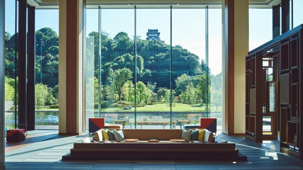 a large room with a couch in front of a large window at Hotel Indigo Inuyama Urakuen Garden by IHG in Inuyama