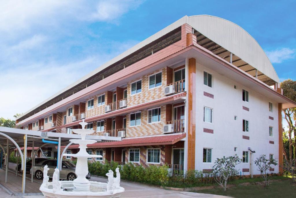 a large building with a fountain in front of it at Baan Bangrak Residence in Trang