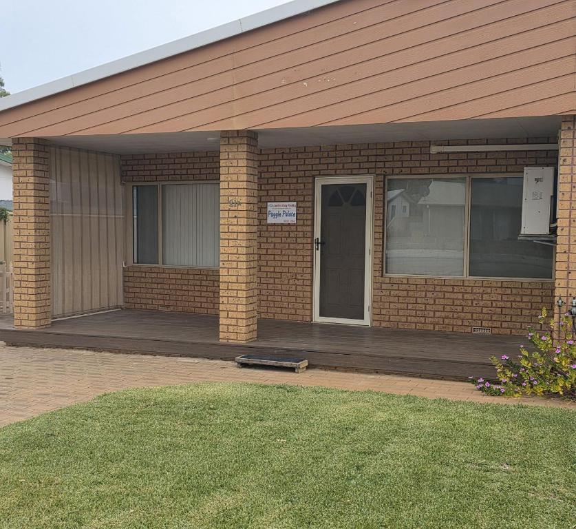 a brick house with a porch and a door at Puggle Palace, 21A Bower Street in Jurien Bay
