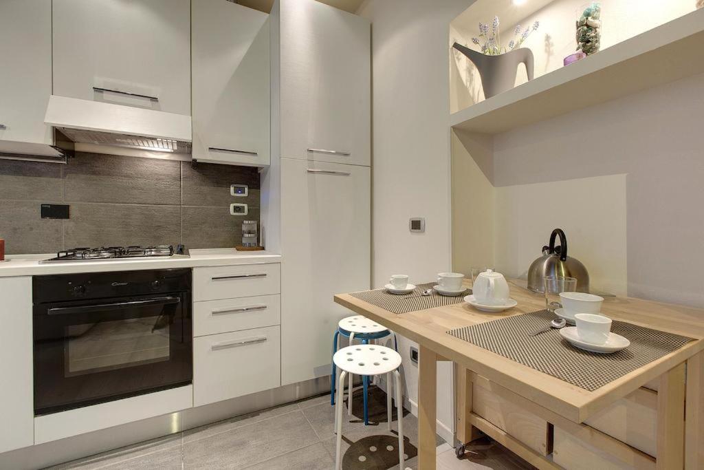 cocina con armarios blancos y encimera de madera en Bargello Guest House, en Florencia