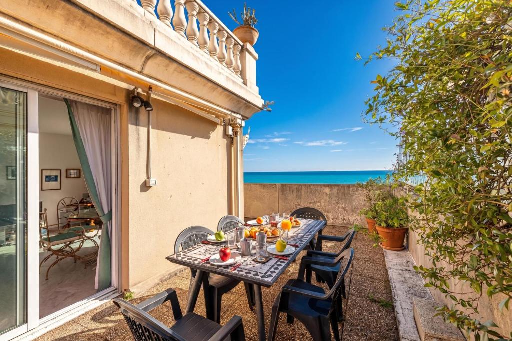 a table on the patio with a view of the ocean at Victoria Sole & Mare with Sea View Terrace - Happy Rentals in Menton