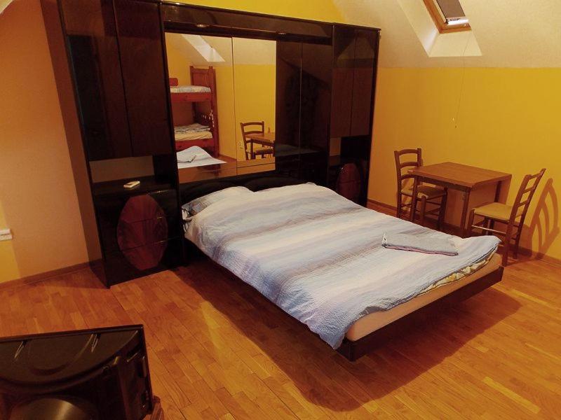 a bedroom with a large bed with a wooden headboard at Hostel Kavala in Belgrade