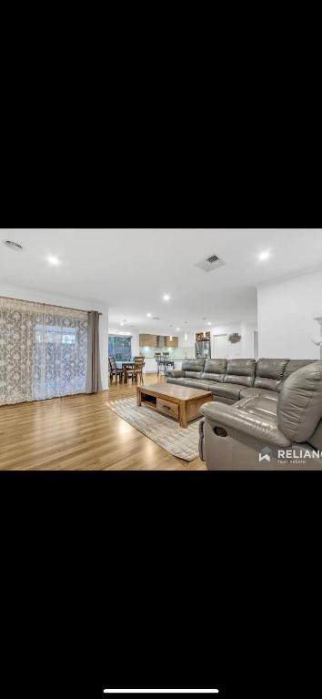 a living room with a couch and a table at Lavish private room1 in Truganina