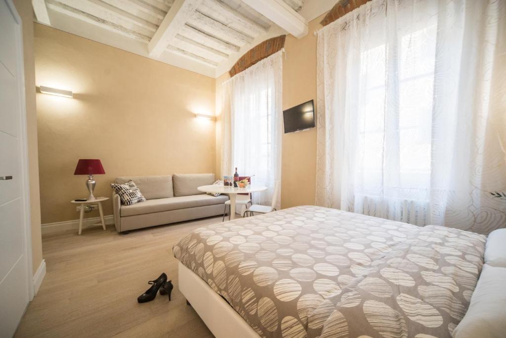 a bedroom with a bed and a couch and a window at Apartments Lorenzo&Lorenzo in Florence