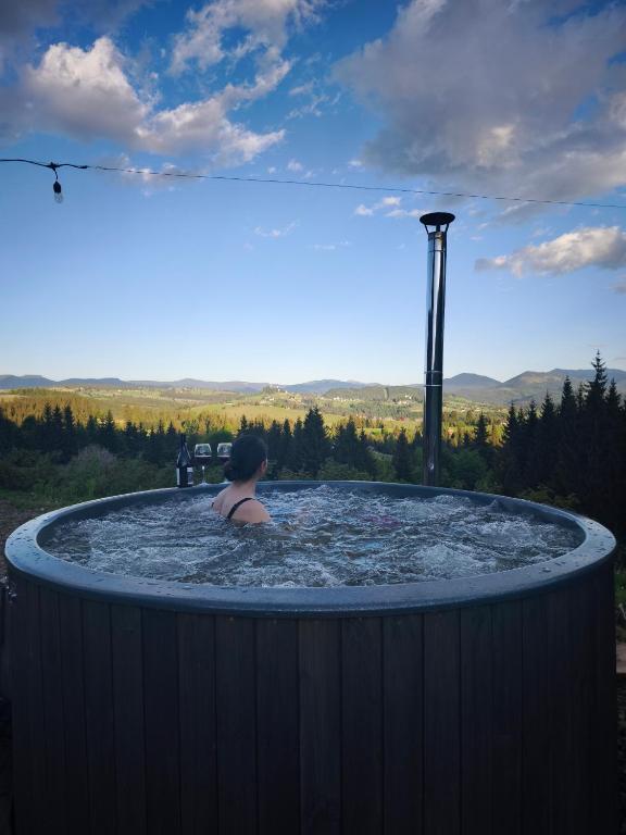 a person in a jacuzzi tub with a view at Noapte de Poveste in Piatra Fantanele