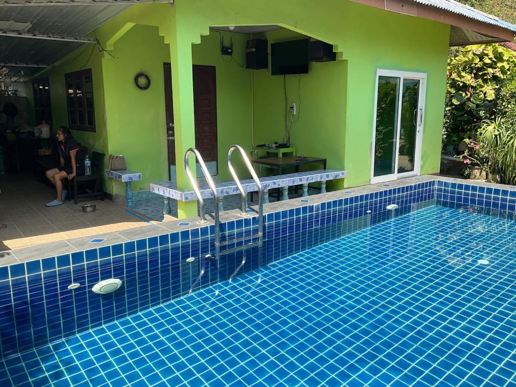 a swimming pool with two toilets in a house at Khwaeng Phao Beech Poolvilla in Ban Thung Khanan
