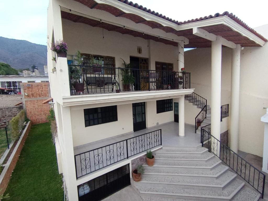 a white building with stairs and a balcony at Casa Lago de Luz in San Juan Cosalá