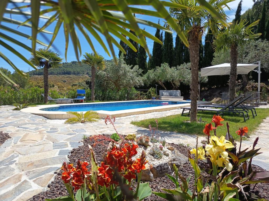 a garden with a swimming pool and some flowers at La Única in Coín