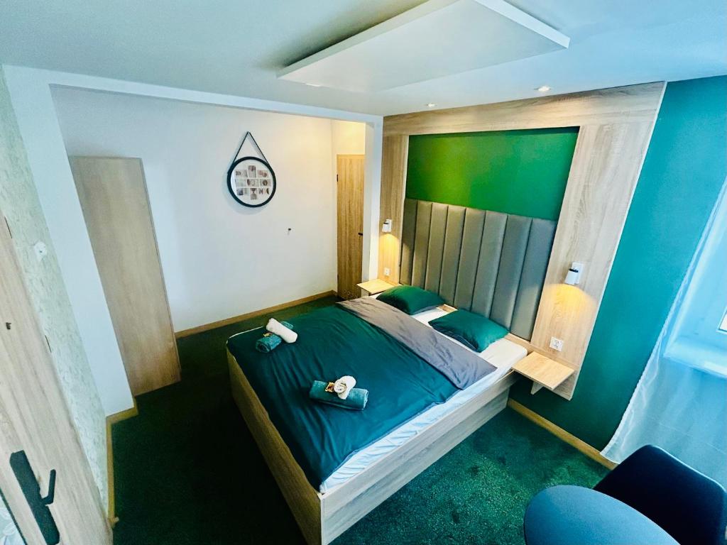 a bedroom with a bed with a clock on the wall at Stacja Jeżyce Pokój #B in Poznań