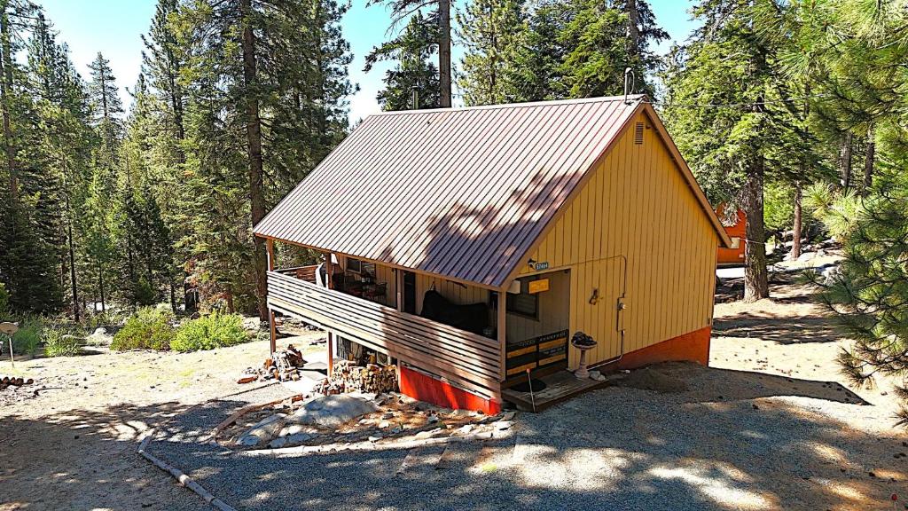 a smallshed with a tin roof in a forest at Beautiful Sierra Mountain Cabin in Springville