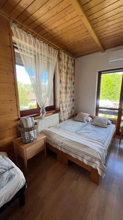 a bedroom with two beds and two windows at Eko Dworek tylko 1500m do wejścia Energylandii in Zator