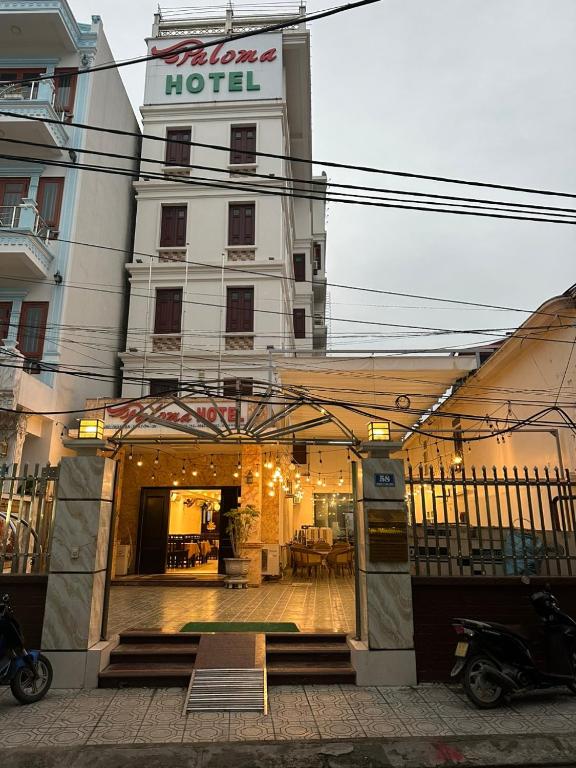a hotel with a sign on the front of it at Paloma Hotel Quan Lan in Quan Lạn
