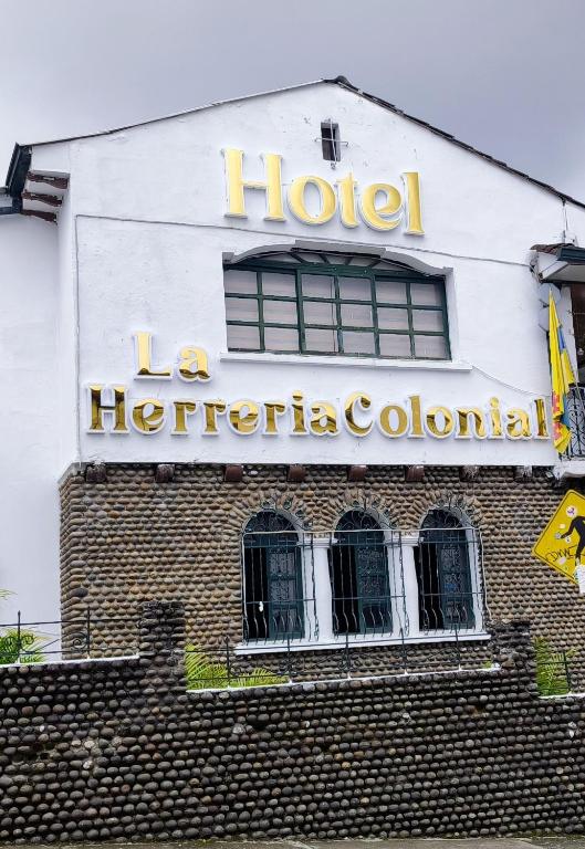 a hotel sign on the side of a building at Hotel La Herreria Colonial in Popayan