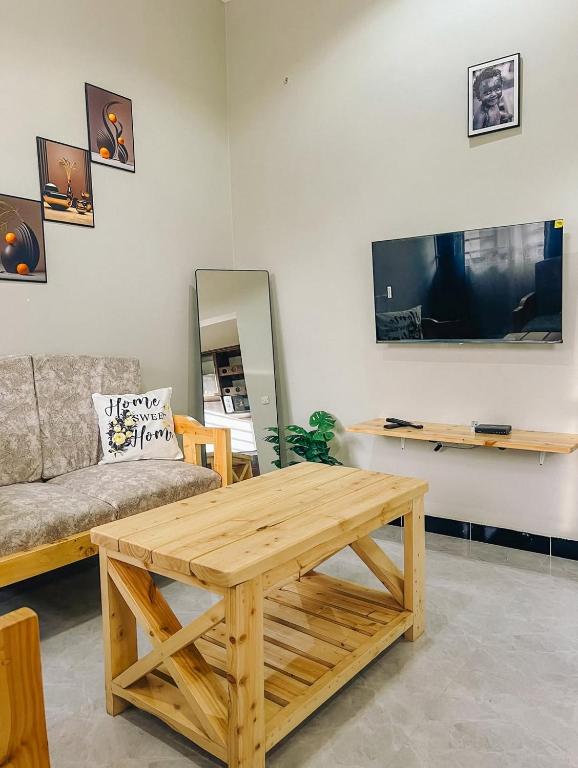 a living room with a wooden coffee table and a couch at SINDOM APARTMENTS Dodoma in Dodoma