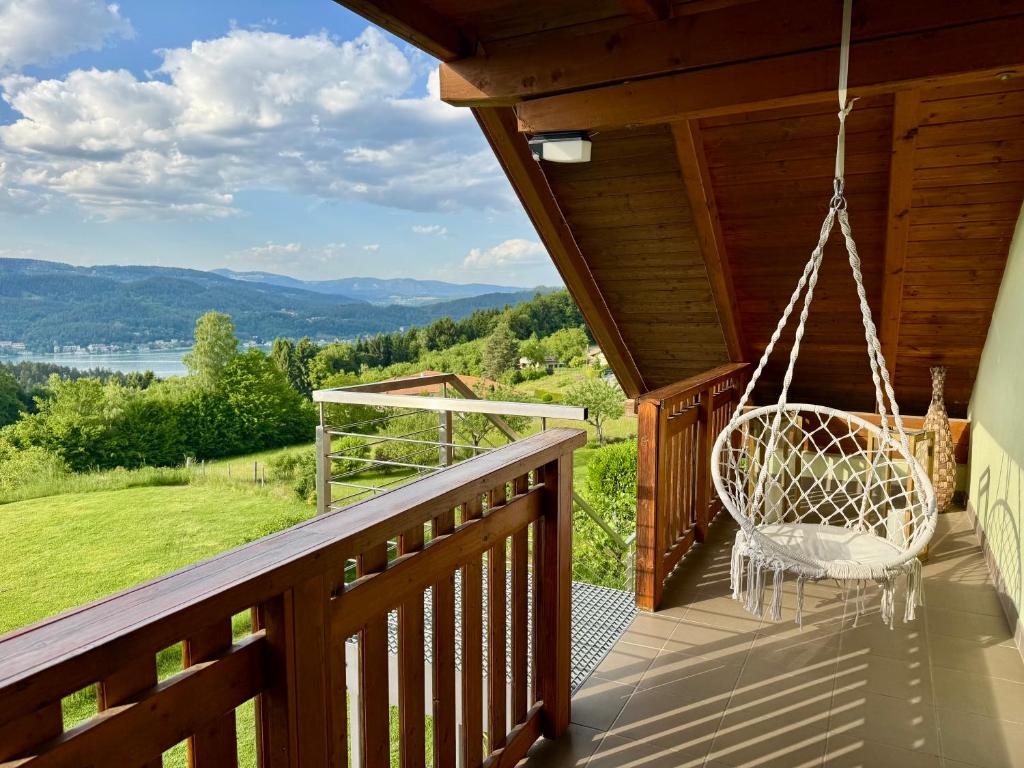 a porch with a swinging chair on a cabin at Danny's Wörtherseeblick in Schiefling am See