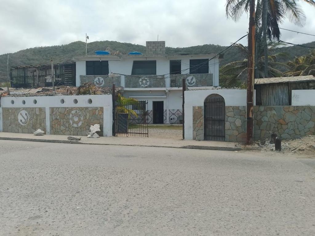 a house with graffiti on it on the side of the road at POSADA VSTIKIBAR & RESTAURANt in Rincón del Pirata