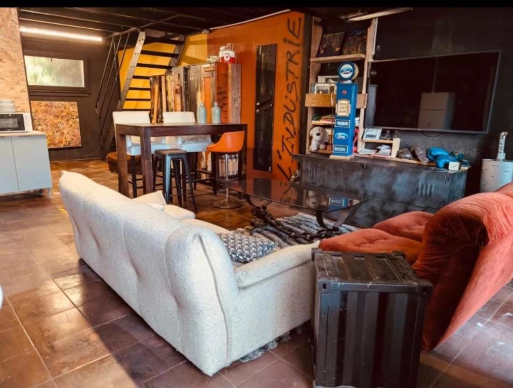 a living room with a white couch and a table at La Mariefacture - Comme au Garage in Laning