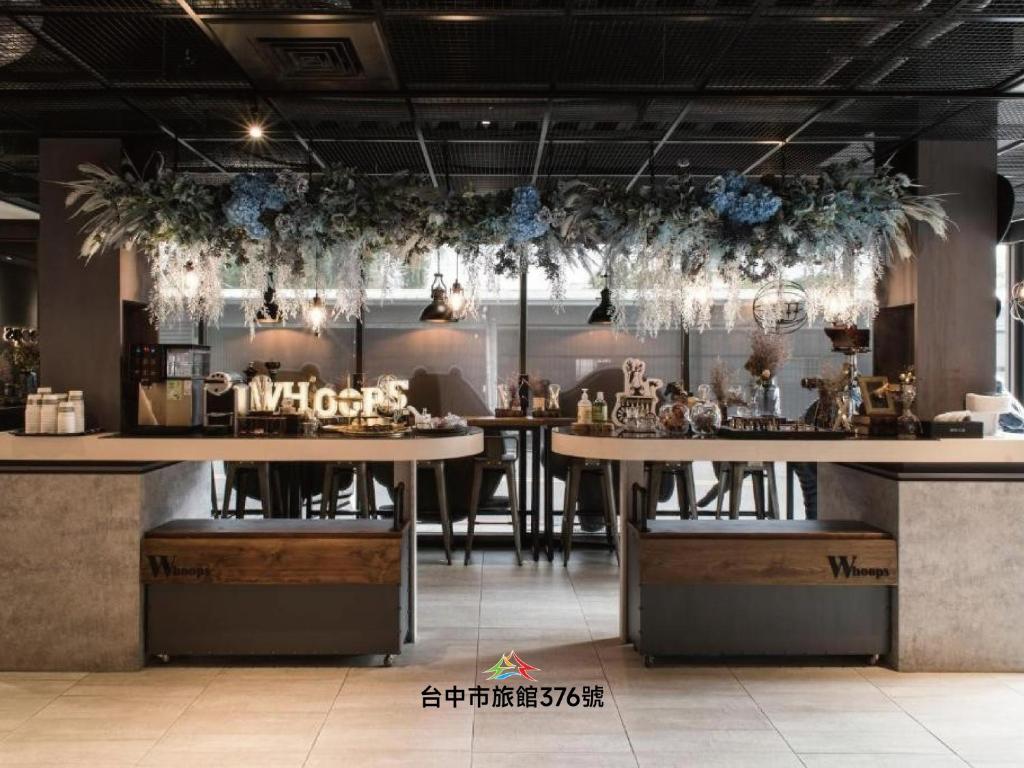 a restaurant with tables and chairs in a room at Whoops Hotel in Taichung