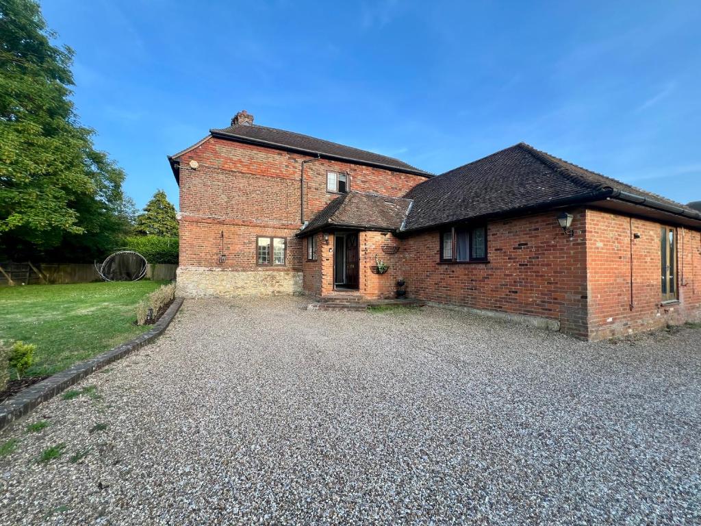 an old brick house with a gravel driveway at Summerhill by suspire in Ashford