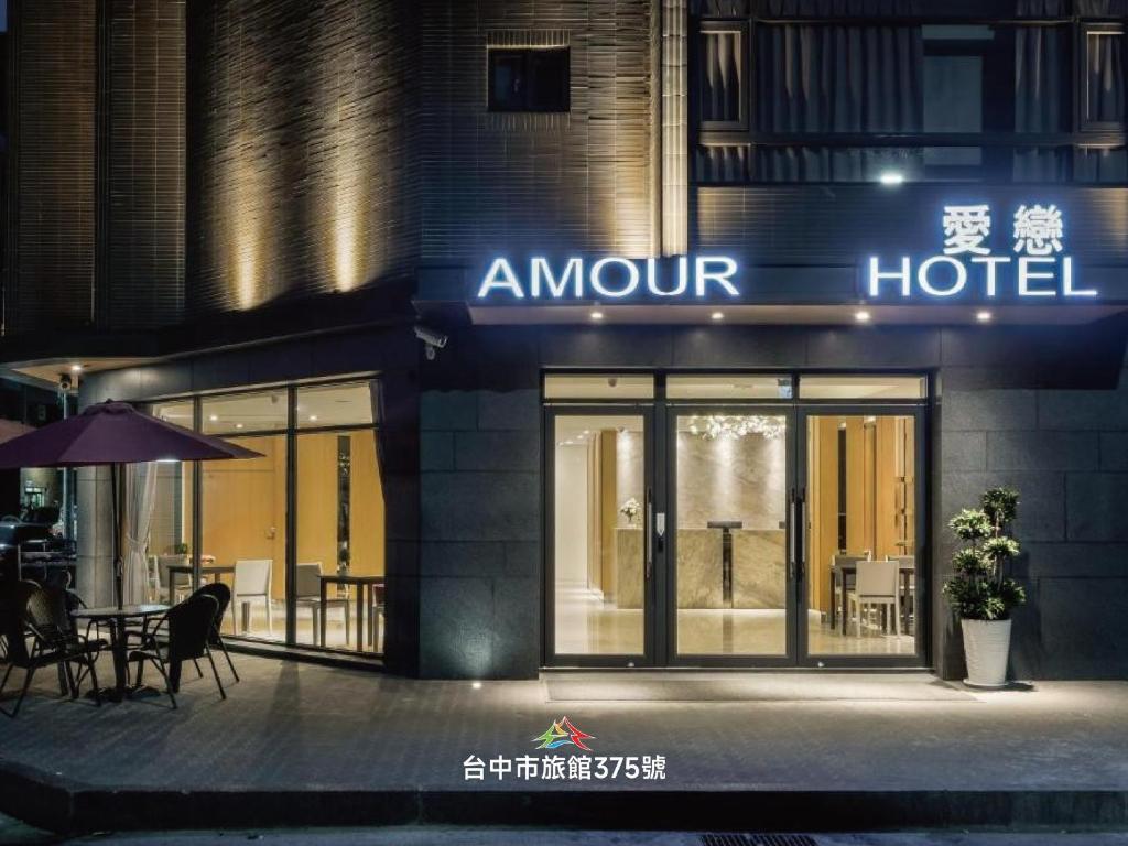 a hotel with a table and chairs in front of a building at Taichung Amour Hotel in Taichung