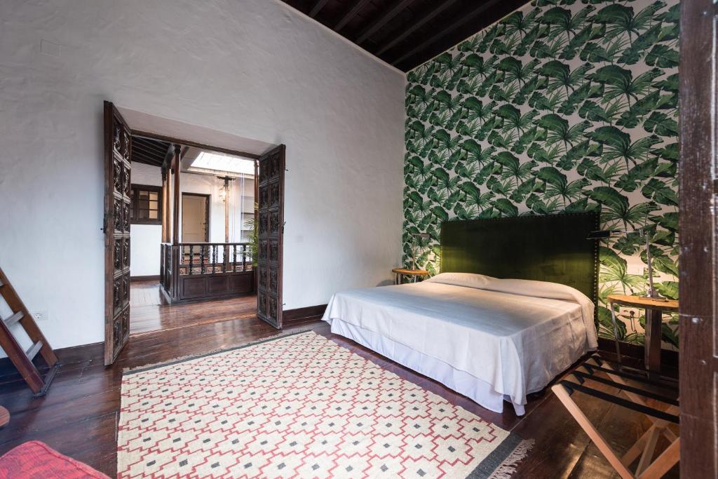 a bedroom with a bed and a green wall at Casa Espiritu Santo in Las Palmas de Gran Canaria