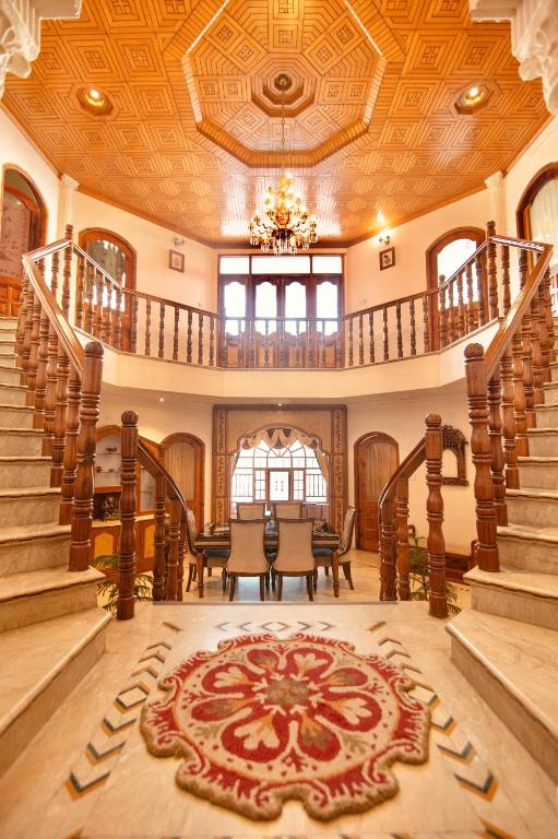 a large room with a staircase and a table and chairs at Cedar Cottage in Shimla