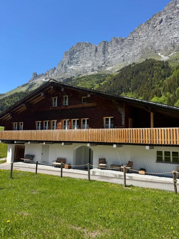 a building with benches in front of a mountain at Chalet Gadmer Herz in Gadmen