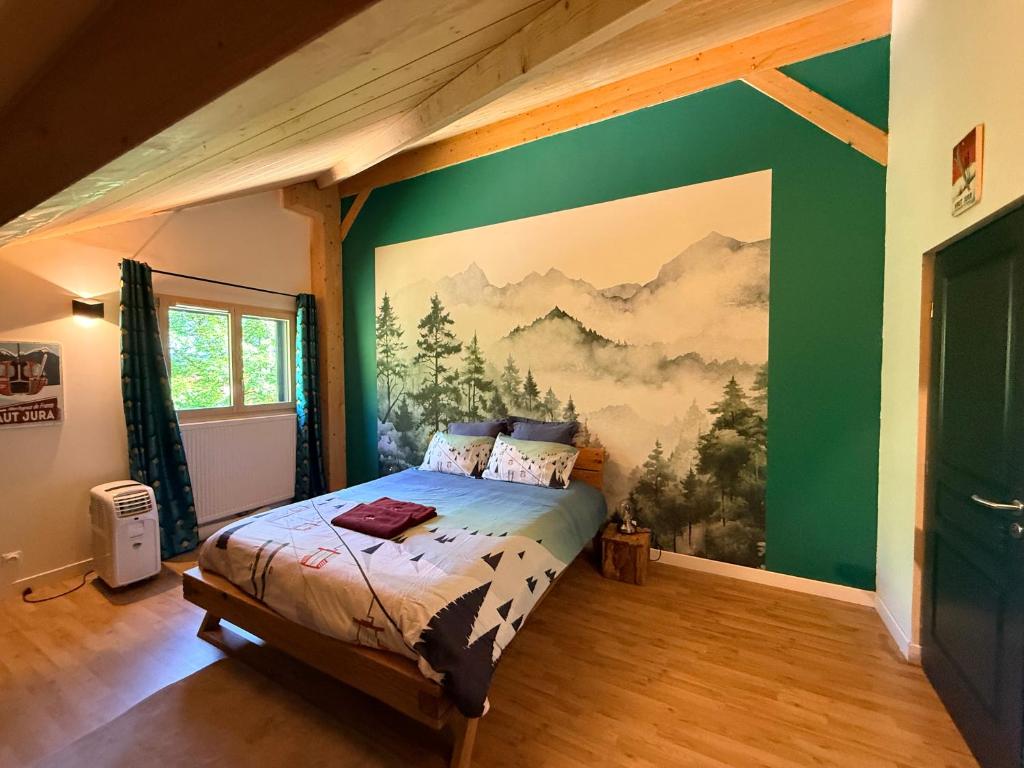 a bedroom with a bed with a painting on the wall at LES ANTHOCYANES CHAMBRE MONTAGNE in Champagny