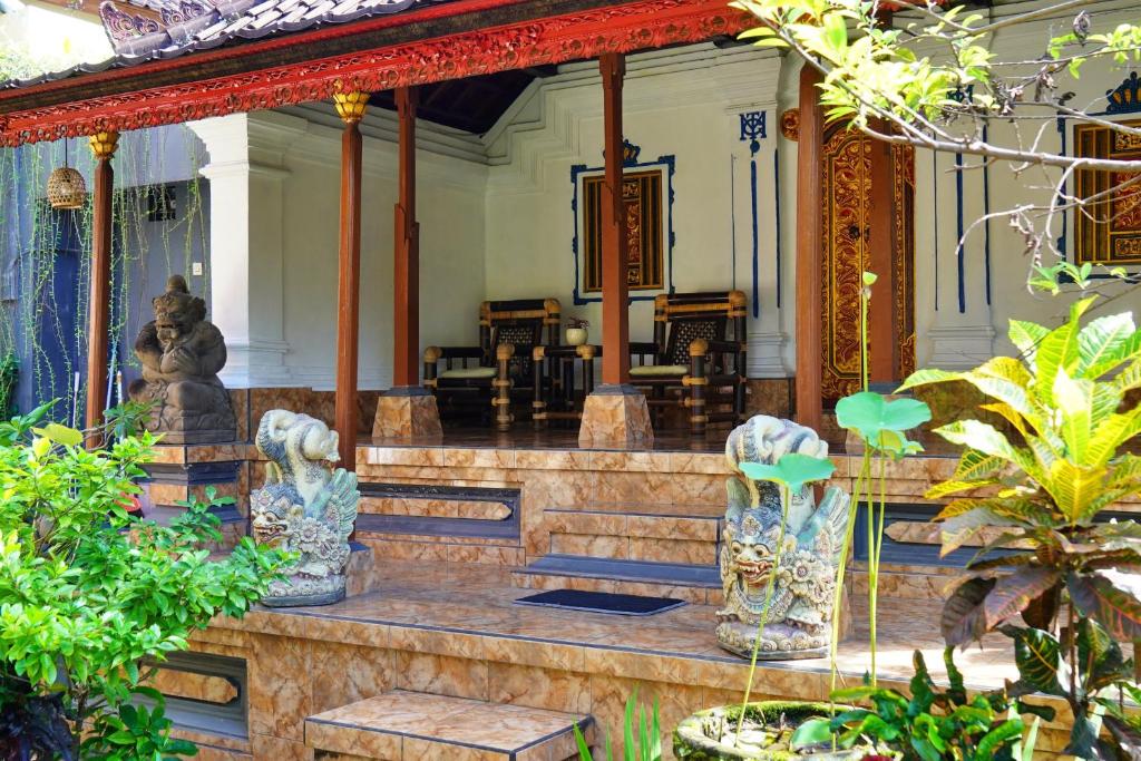 a house with a staircase in the middle of it at Tegeg's Homestay in Keramas