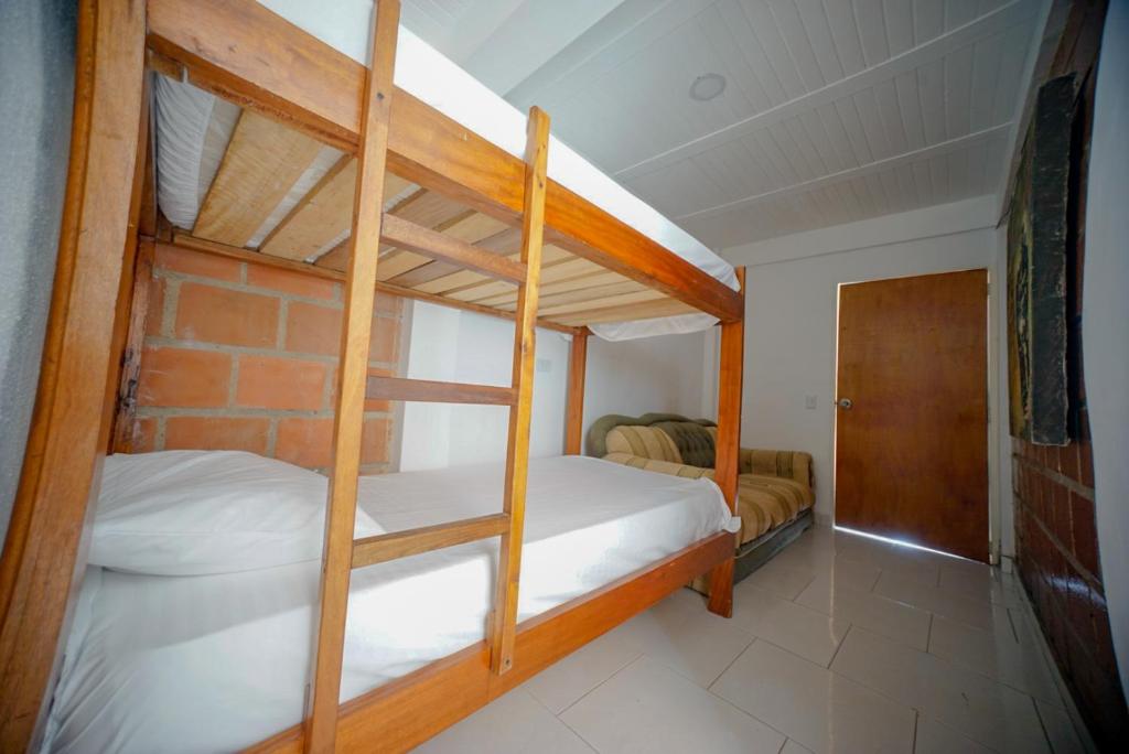 a bedroom with two bunk beds and a door at Casa corazón del pueblo in Calima