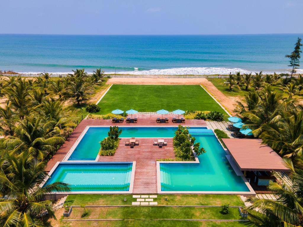 an aerial view of a resort with a pool and the ocean at Aprota Villas in Arugam Bay