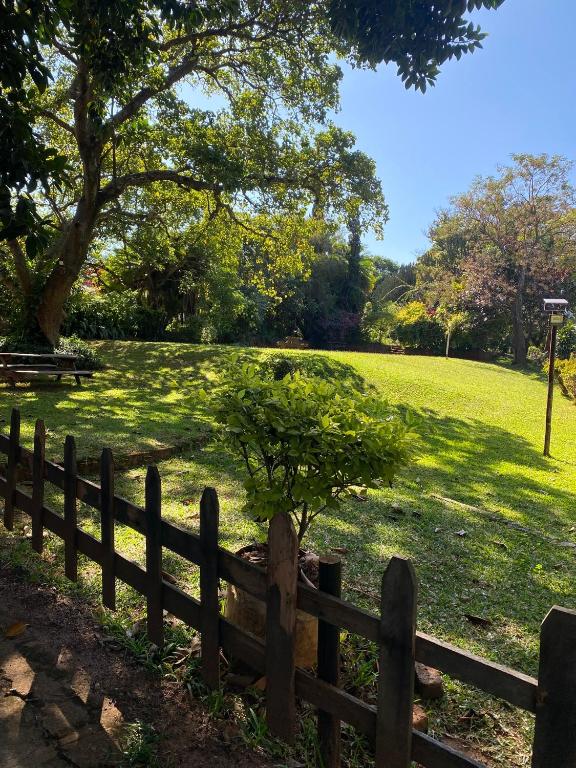 a wooden fence with a small tree in a field at Green Whisper BnB in Umtali