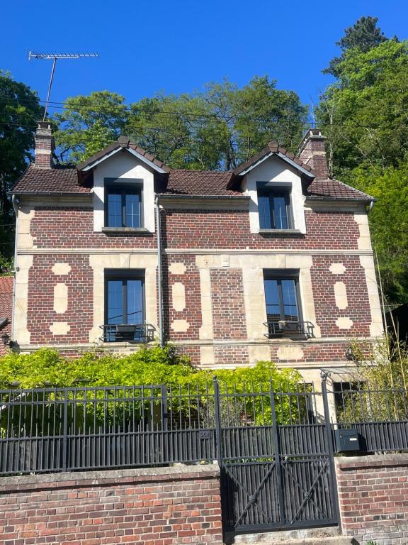 an old brick house with a black fence at Maison de caractère familiale in Béthisy-Saint-Martin