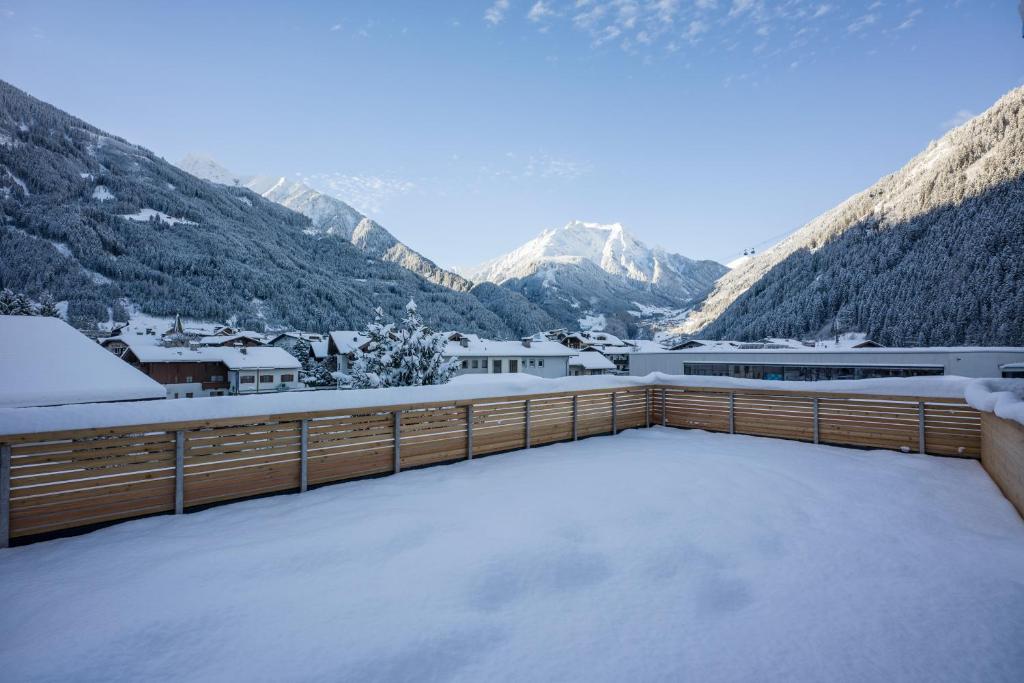 a snow covered balcony with mountains in the background at Postresidenz in Mayrhofen