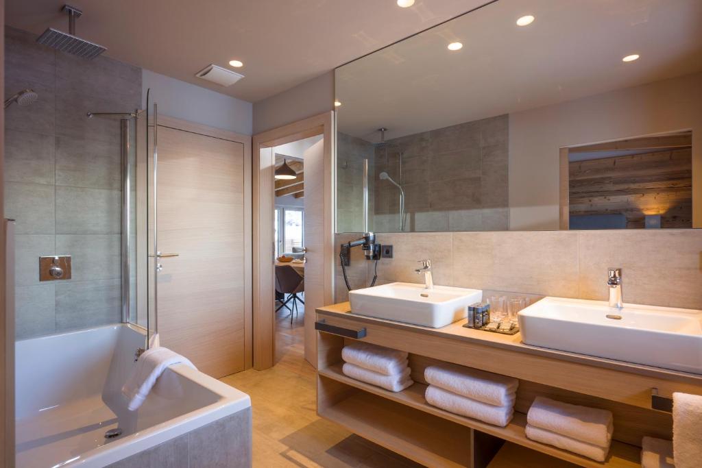 a bathroom with two sinks and a bath tub at Postresidenz in Mayrhofen