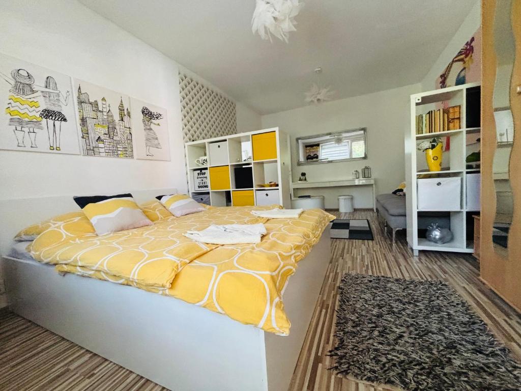 a bedroom with a large bed with a yellow bedspread at Apartment city centrum in Nitra