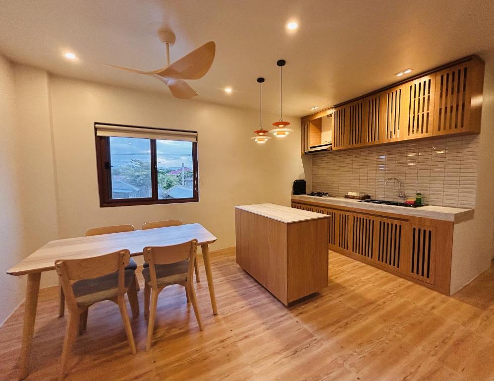 a kitchen with a table and chairs in a room at Ikigai Narvacan Hometel in Narvacan