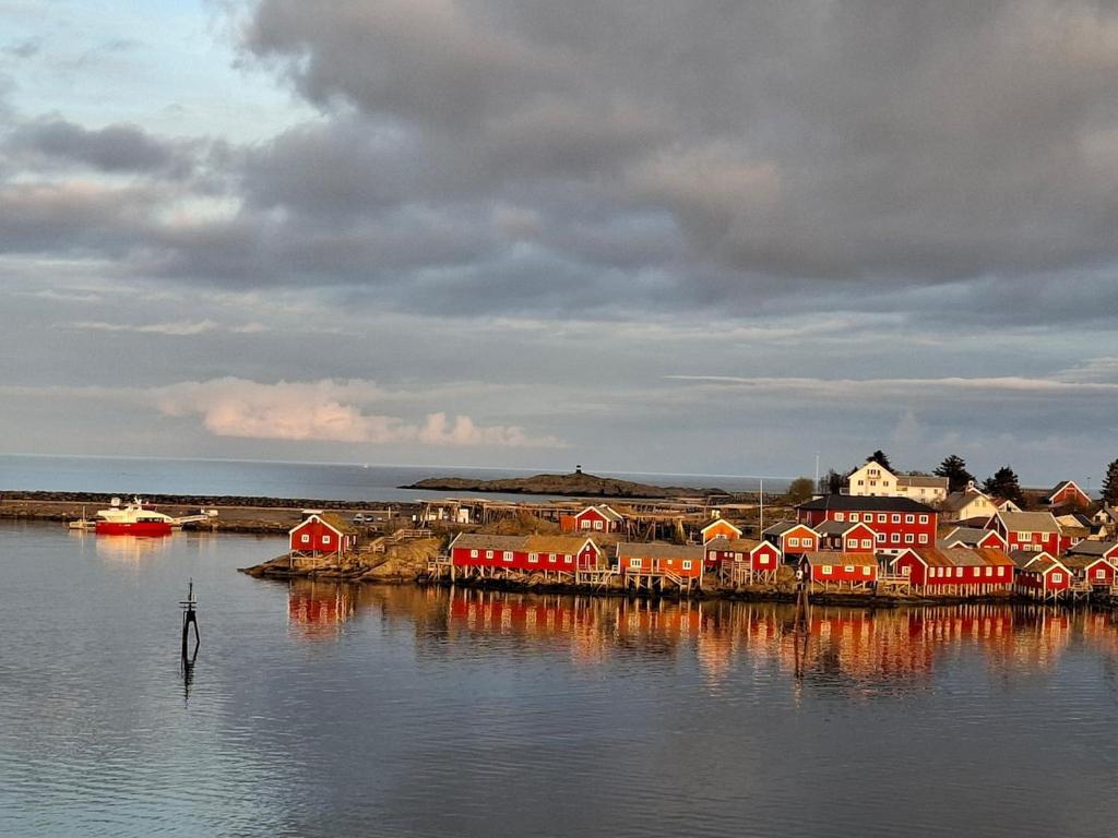 a group of red houses on a island in the water at Reine Viewpoint House in Reine