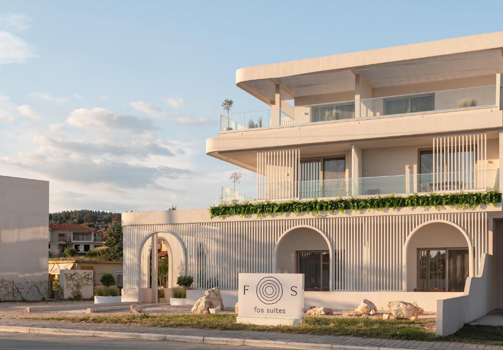 a building with a sign in front of it at FOS Luxury Suites in Nikiti