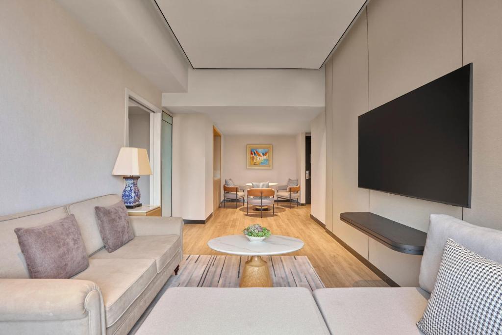 a living room with a couch and a flat screen tv at Sheraton Hanoi Hotel in Hanoi