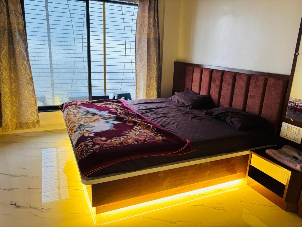 a bedroom with a bed with a wooden frame and a window at Garbat valley view Matheran in Matheran