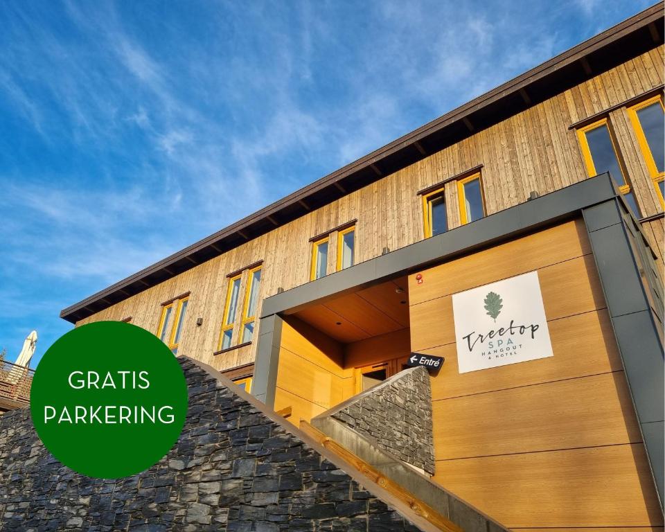 a building with a wooden door with a sign on it at Treetop Spa Hangout & Hotel in Gothenburg