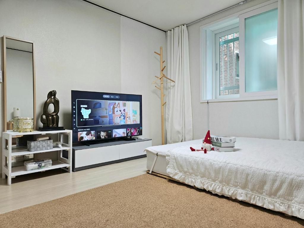 a bedroom with a flat screen tv and a bed at 행궁동-House1 in Suwon