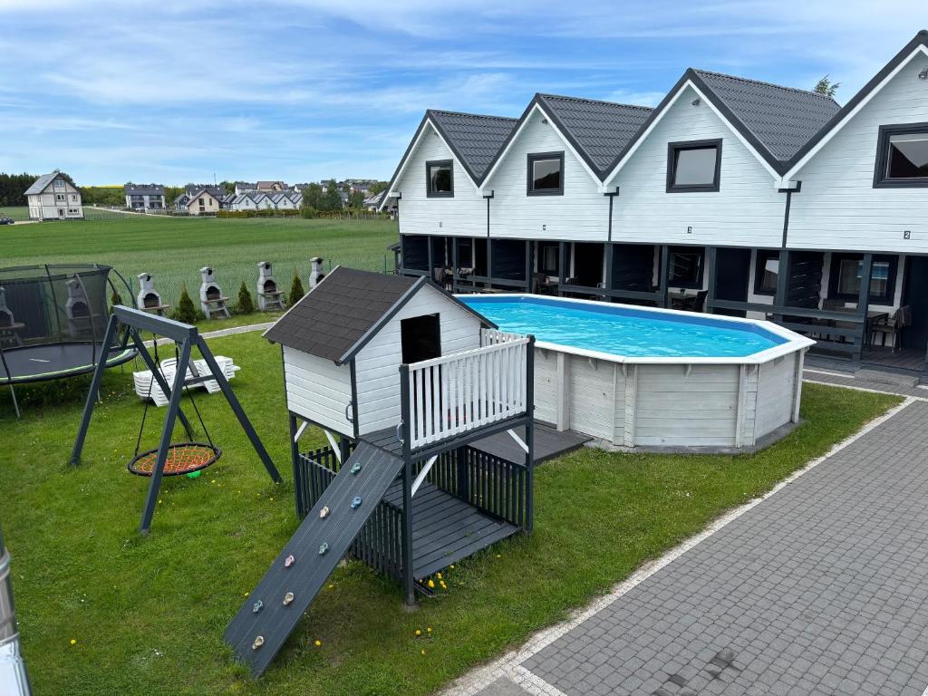 a playground with a slide and a swimming pool at Domki letniskowe Nadia z podgrzewanym basenem in Władysławowo