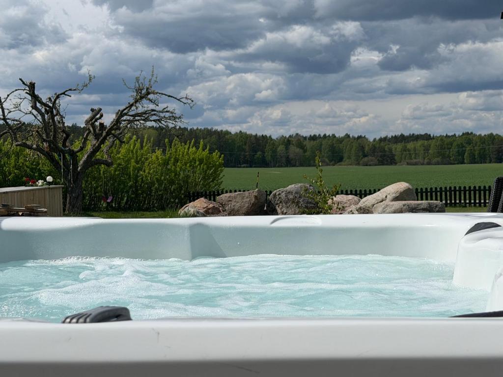 a jacuzzi tub in a yard with a field at Swedish countryside jacuzzi and pool! in Uppsala